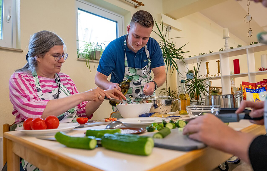 Zwei Personen bereiten in einer Küche Gemüse zu.
