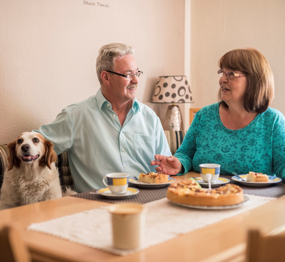 Gallery-Image-Senioren-mit-Hund Senioren sitzen mit Hund am Esstisch