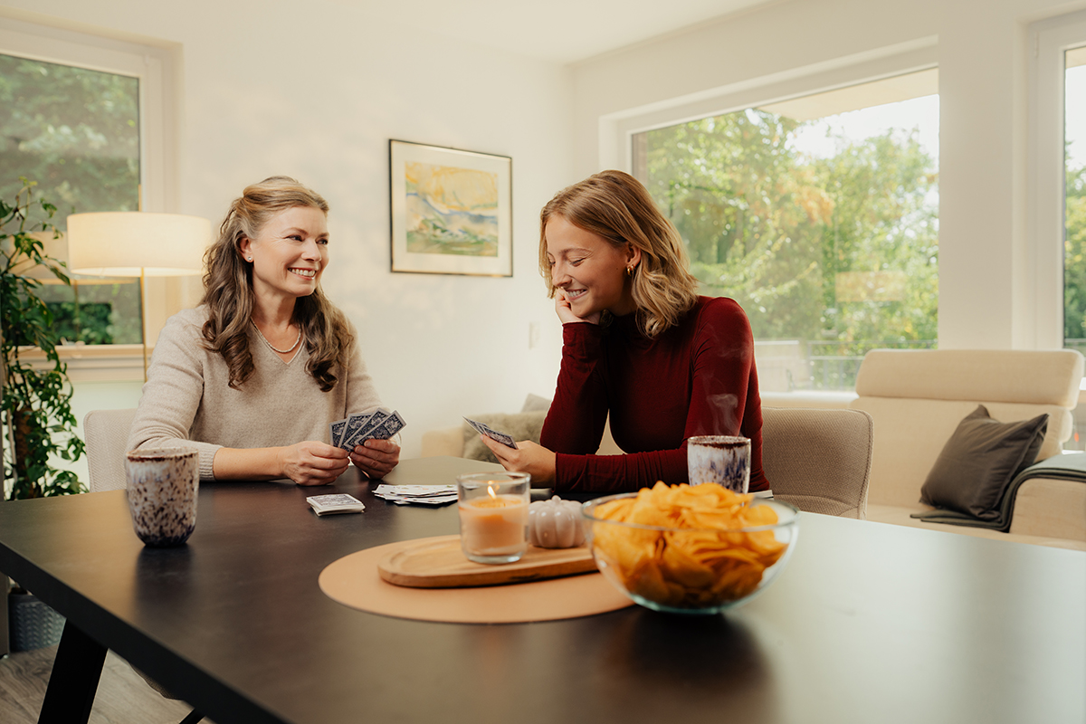 Zwei Frauen sitzen am Tisch und spielen Karten