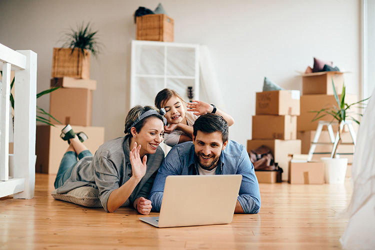 Glückliche Familie winkt während eines Videoanrufs aus der neuen Wohnung Glückliche Familie winkt während eines Videoanrufs aus der neuen Wohnung