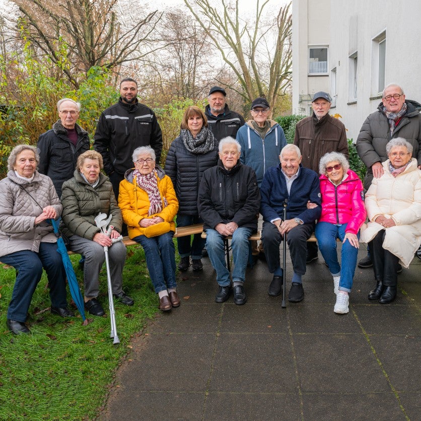 Gruppe von Mietern sitzen auf Bänken.